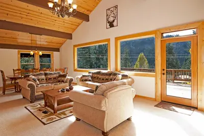a living room with couches and a table and windows at Valley View at Palisades -4 BR w Mountain Views, Pet-Friendly, and Close to Village in Olympic Valley