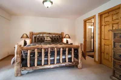 a bedroom with a large wooden bed with two lamps at Valley View at Palisades -4 BR w Mountain Views, Pet-Friendly, and Close to Village in Olympic Valley
