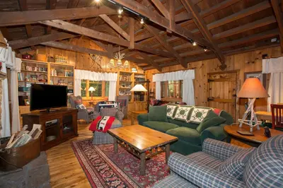 a living room with a green couch and a tv at Ward Creek Retreat - Cozy Old Tahoe Cabin w Short Drive to Ski Resorts Pet Friendly in Tahoe City