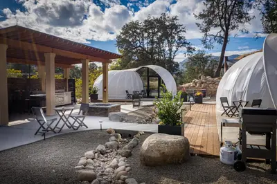 a backyard with two domes and a patio with rocks at Sequoia Studio Suites in Three Rivers