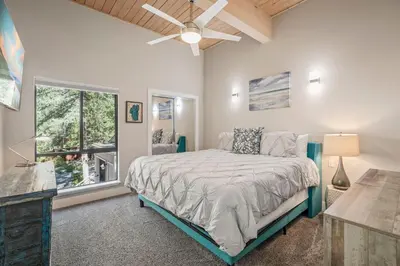 a bedroom with a bed with a ceiling fan and a window at The perfect Forest Pines getaway in Incline Village