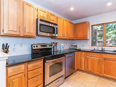 a kitchen with wooden cabinets and stainless steel appliances at 252 McCloud Upper level unit in Incline Village