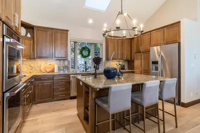 a kitchen with wooden cabinets and a island with bar stools at Fabulous Views Of Lake Tahoe in Crystal Bay