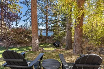 two chairs and a table in a park with trees at Fabulous Views Of Lake Tahoe in Crystal Bay