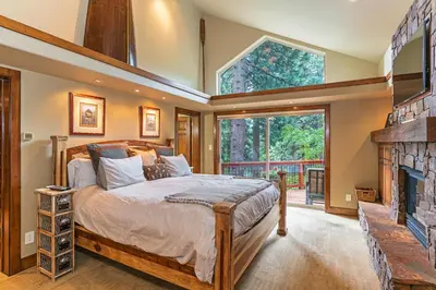 a bedroom with a large bed and a fireplace at 585 Knotty Pine - Gorgoeous Moutain Home in Incline Village
