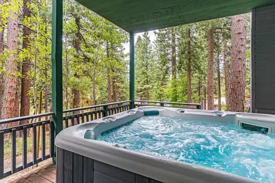 a hot tub on a deck with trees at 585 Knotty Pine - Gorgoeous Moutain Home in Incline Village