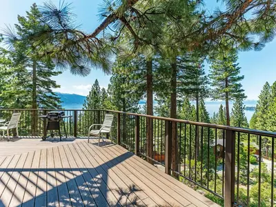 a wooden deck with chairs and a table on it at Enjoy the brilliant views of Lake Tahoe from this mountainside Cabin in Incline Village