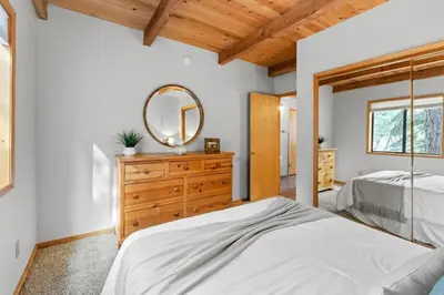 a bedroom with a bed and a mirror on a dresser at Tranquil Tahoe A-Frame Walk to Beach in Tahoe Vista