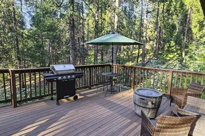 a grill and an umbrella on a wooden deck at Casa nel Bosco in Arnold