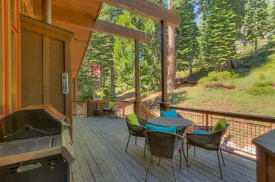 a screened porch with a table and chairs and a stove at Fairway Favorite - Walk to Tahoe City Shops, Dining & Lake - Pet Friendly in Tahoe City