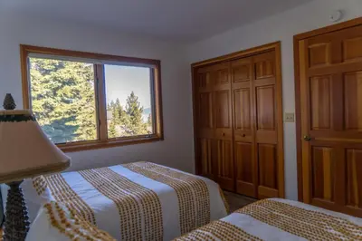 a bedroom with two beds and a window at Sierra Lake View at Rubicon by Tahoe Getaways - 3 BR, Panoramic Lake Views, Private Hot Tub & Private beach! in Tahoma