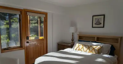 a bedroom with a bed and a window at Sierra Lake View at Rubicon by Tahoe Getaways - 3 BR, Panoramic Lake Views, Private Hot Tub & Private beach! in Tahoma