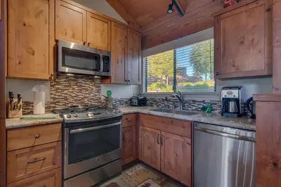 a kitchen with wooden cabinets and stainless steel appliances at Rocky Point #93 3BR Townhome in Northstar - Shuttle to Slopes - HOA Amenities in Truckee