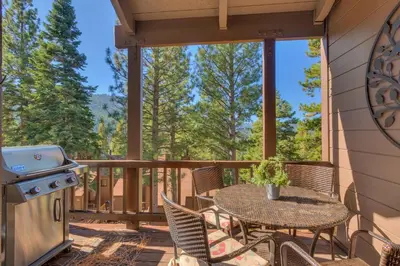 a screened porch with a table and chairs and a grill at Rocky Point #93 3BR Townhome in Northstar - Shuttle to Slopes - HOA Amenities in Truckee