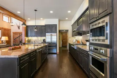 a large kitchen with wooden cabinets and stainless steel appliances at Trestlewood Lodge at Schaffers Mill - Gorgeous 3 BR w Golf Course Views - Extended Stays Welcome! in Truckee