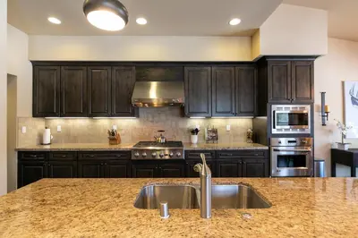 a kitchen with wooden cabinets and a sink at Trestlewood Lodge at Schaffers Mill - Gorgeous 3 BR w Golf Course Views - Extended Stays Welcome! in Truckee
