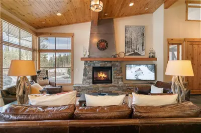 a living room with a leather couch and a fireplace at Trestlewood Lodge at Schaffers Mill - Gorgeous 3 BR w Golf Course Views - Extended Stays Welcome! in Truckee