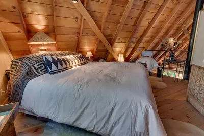 a bedroom with a large bed in a wooden ceiling at Falcon's Rest - Ski and Summer Cabin in The Heart of North Lake Tahoe- Gas Fireplace in Carnelian Bay