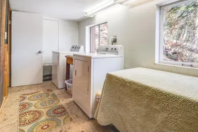 a bedroom with a bed and a sink and a window at Serene Lakes Cabin with Deck Dog Friendly! in Soda Springs