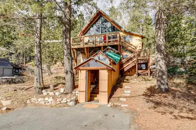 a tree house in the woods with a garage at Serene Lakes Cabin with Deck Dog Friendly! in Soda Springs