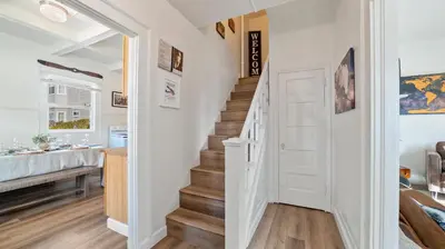 a staircase in a home with white walls and wooden floors at Midtown Flight Deck: 2BR Gem in Reno