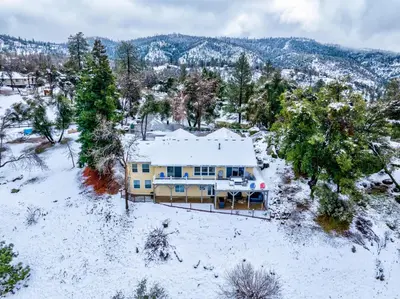 an aerial view of a house in the snow at Yosemite Bass Lake VIEWS, 2 Homes, Games, Hot Tub in Coarsegold