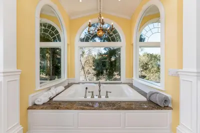 a bathroom with a tub and two windows at Yosemite Bass Lake VIEWS, 2 Homes, Games, Hot Tub in Coarsegold