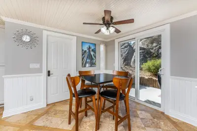 a dining room with a table and chairs and a ceiling fan at Yosemite Bass Lake VIEWS, 2 Homes, Games, Hot Tub in Coarsegold