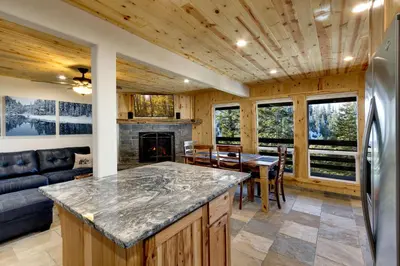 a kitchen and living room with a couch and a fireplace at Tall Pine Chalet in Stateline