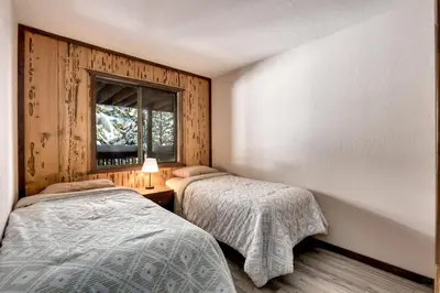 two beds in a room with a window at Snowflake Chalet in Stateline