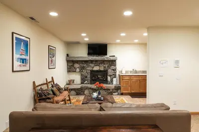 a living room with a couch and a stone fireplace at Silver Rock Lodge in Zephyr Cove