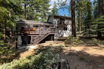 a house with a deck in the woods at Panhandle House in South Lake Tahoe