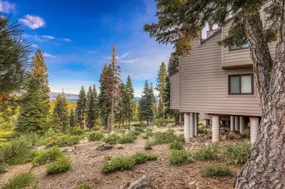 a house on a hill with trees in the background at Stylish 2BD in Carnelian Bay in Carnelian Bay