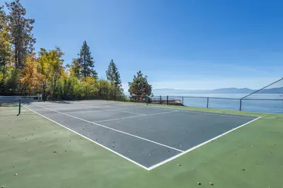 a tennis court next to a body of water at VIP Lakefront Condo Amazing Views Pool Pickleball Excellent Location Balcony BBQ in Kings Beach
