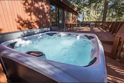 a hot tub on the deck of a house at Luna Cabin - 5BR Hot Tub A/C Game Room EV Charger in Tahoe Vista