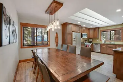 a kitchen with a wooden table and a dining room at Luna Cabin - 5BR Hot Tub A/C Game Room EV Charger in Tahoe Vista
