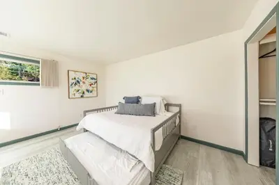 a white bedroom with a bed and a window at Starry Night Cabin at Sky Ranch in Oakhurst