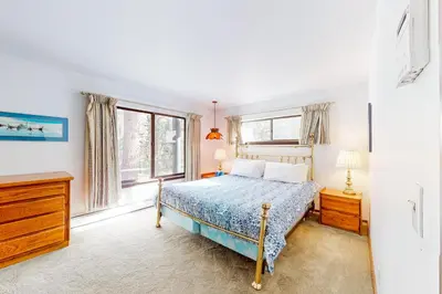 a bedroom with a bed and two windows at Antler & Pine in South Lake Tahoe