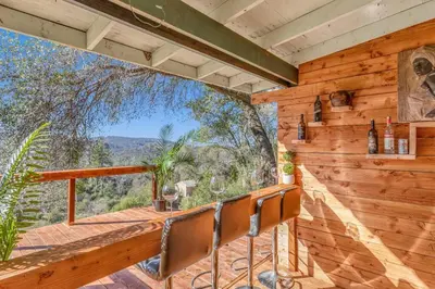 a room with a balcony with a table and chairs at Cozy Cabin on 10 acres in Pilot Hill