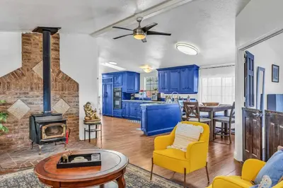 a living room with blue cabinets and a fireplace at Cozy Cabin on 10 acres in Pilot Hill