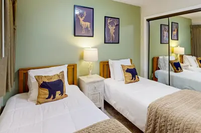 a bedroom with two beds and a mirror at Stagecoach Ski Condo in Stateline