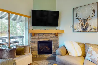 a living room with a fireplace with a flat screen tv at Stagecoach Ski Condo in Stateline