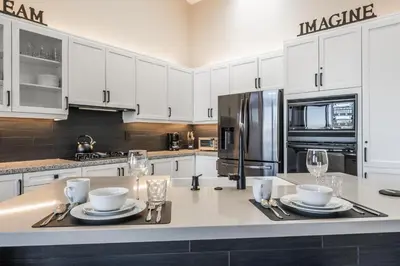 a kitchen with white cabinets and a stainless steel refrigerator at Snowcreek V 972 in Mammoth Lakes