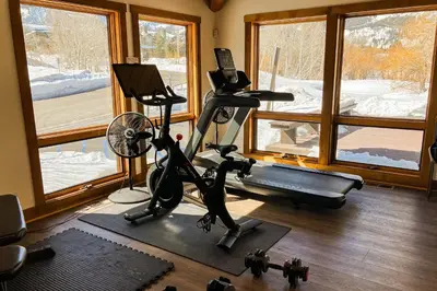 a room with a gym with a treadmill and a window at Creekhouse 1362 in Mammoth Lakes