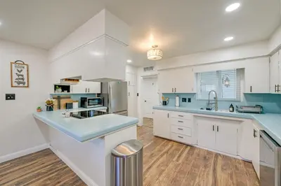 a kitchen with white cabinets and blue counter tops at Visalia Vacation Rental with Yard 1 Mi to Downtown in Visalia