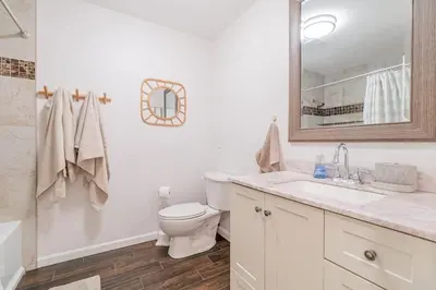 a bathroom with a toilet and a sink and a mirror at Vibrant Boho Home 3 Bed Pet Friendly in Reno