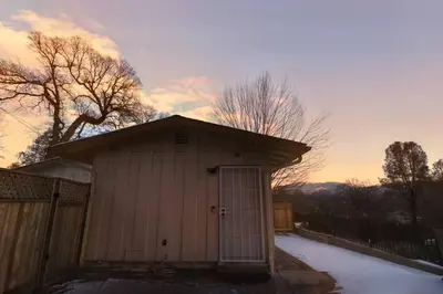 a small building with a door in the snow at Peaceful Yosemite Retreat-King Suite-Pet Friendly in Oakhurst