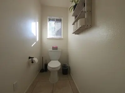a bathroom with a toilet and a window at Peaceful Yosemite Retreat-King Suite-Pet Friendly in Oakhurst