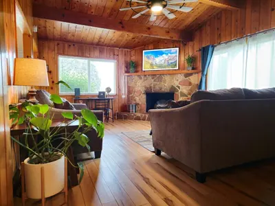 a living room with a couch and a fireplace at Yosemite Gateway Cottage - King Suite - Mountain Views in Oakhurst