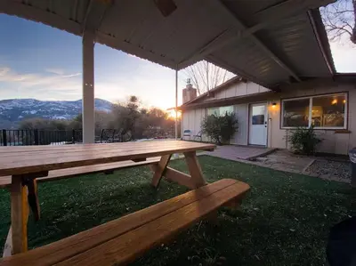a wooden picnic table in front of a house at Yosemite Gateway Cottage - King Suite - Mountain Views in Oakhurst